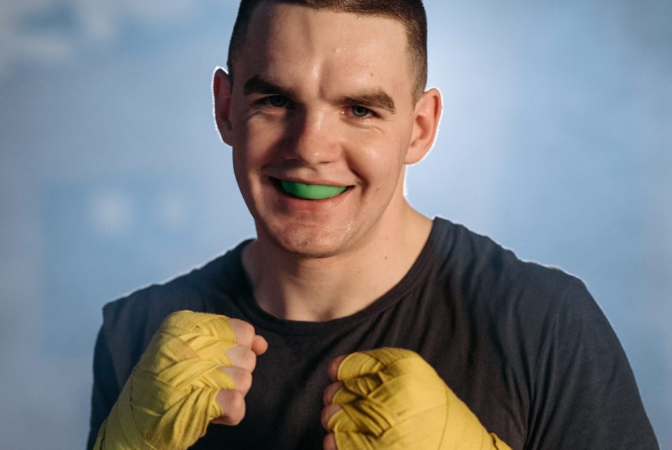 a man participating in boxing and wearing a sports brace mouth guard