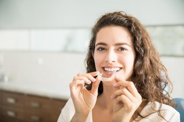 Woman smiling before putting in her Invisalign orthodontic aligner treatment