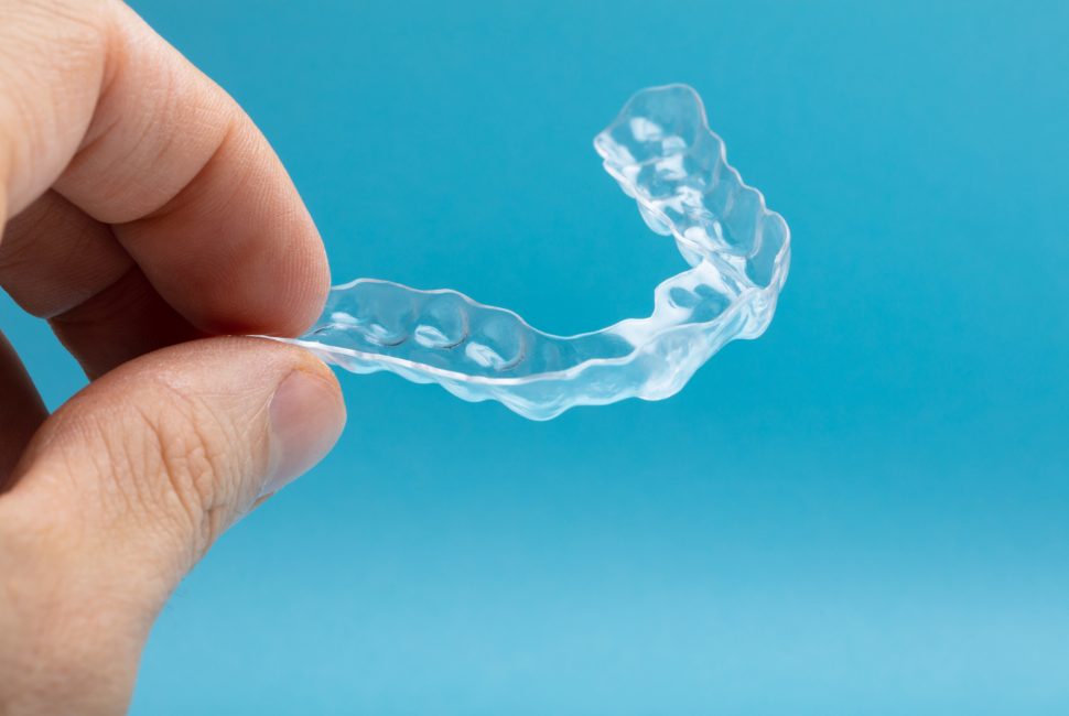 a close-up image of a person holding a retainer