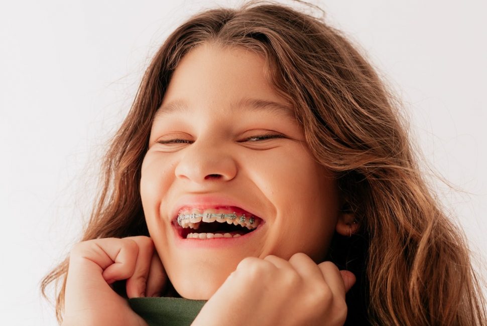 A pre-teen girl with braces smiling