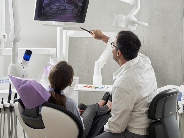 Dentist reviewing bite problem x-ray with patient