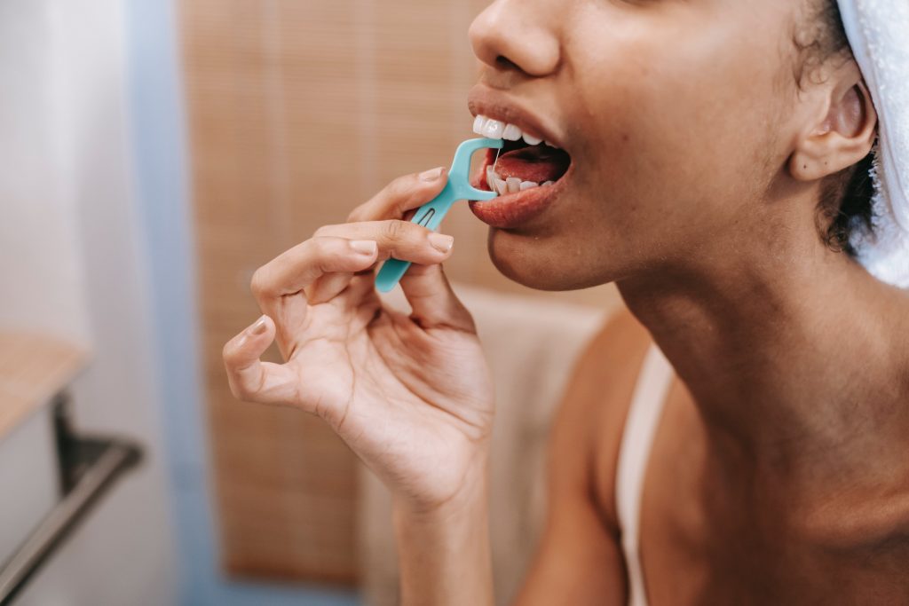 a woman flossing her teeth